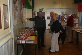 People viewing display of crosses and map showing where 68 men who died are commemorated